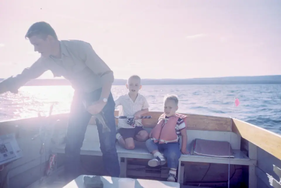 Father and children enjoying a boat ride on a lake