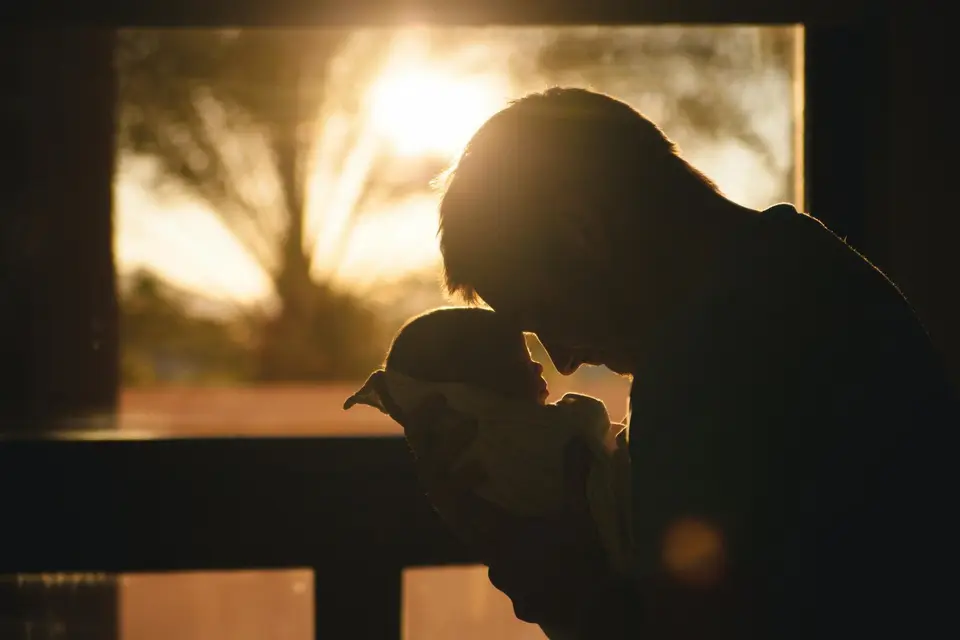Silhouette of a father holding his newborn