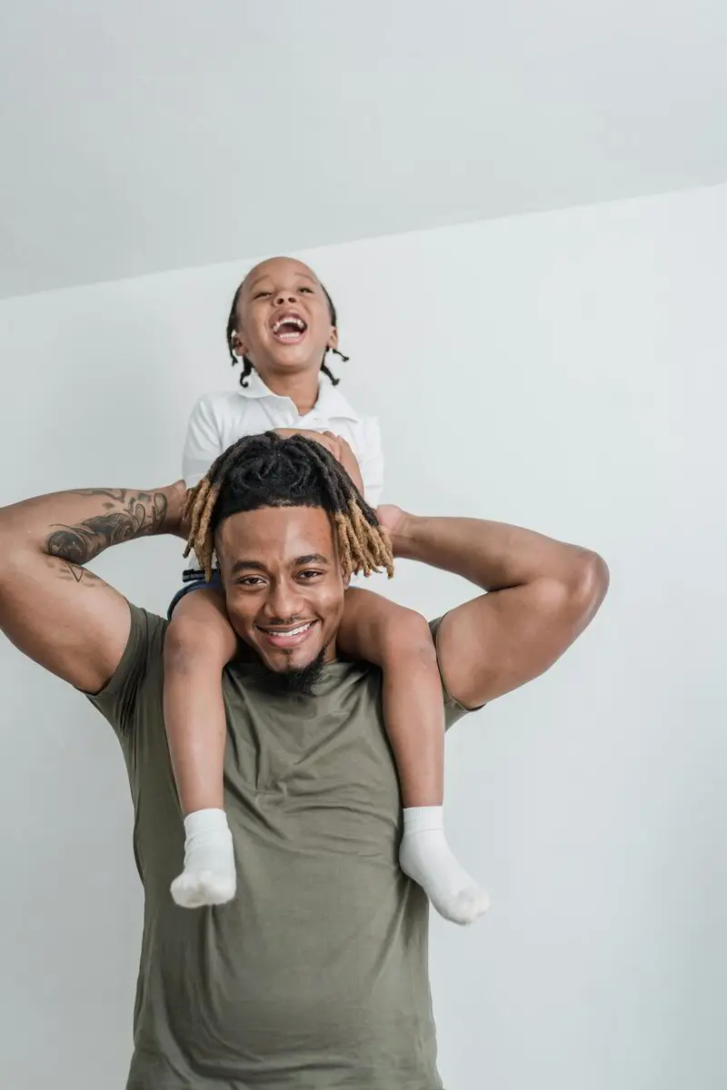 Toddler sitting on dad’s shoulders